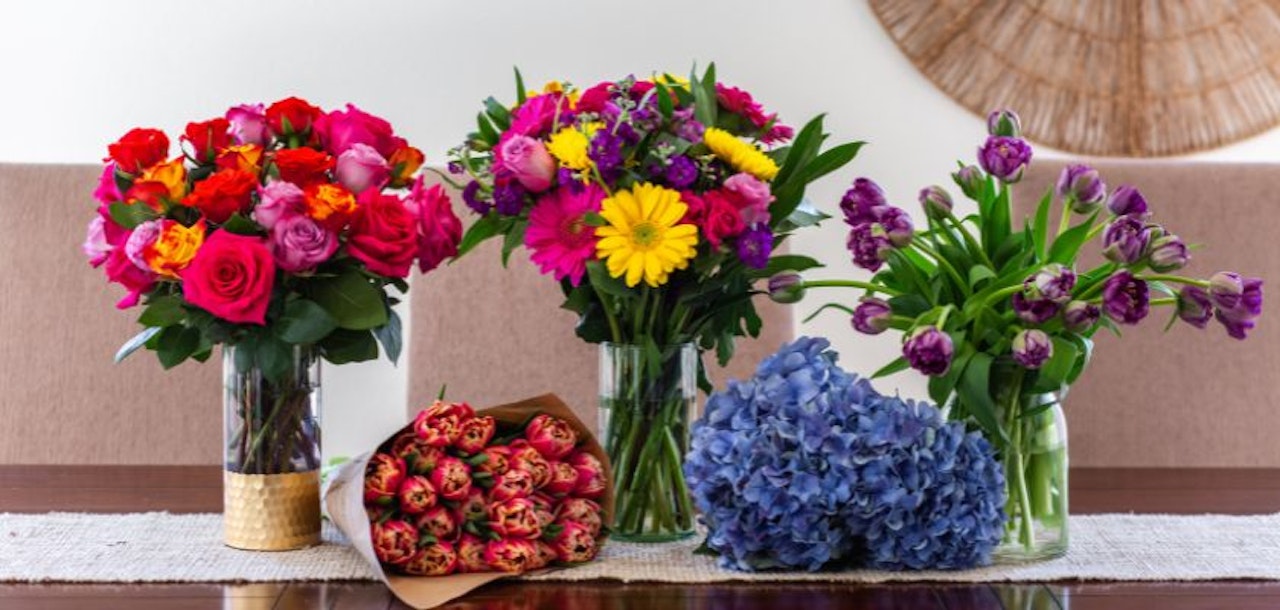 Vibrant floral arrangement featuring roses, tulips, and hydrangeas in elegant vases.