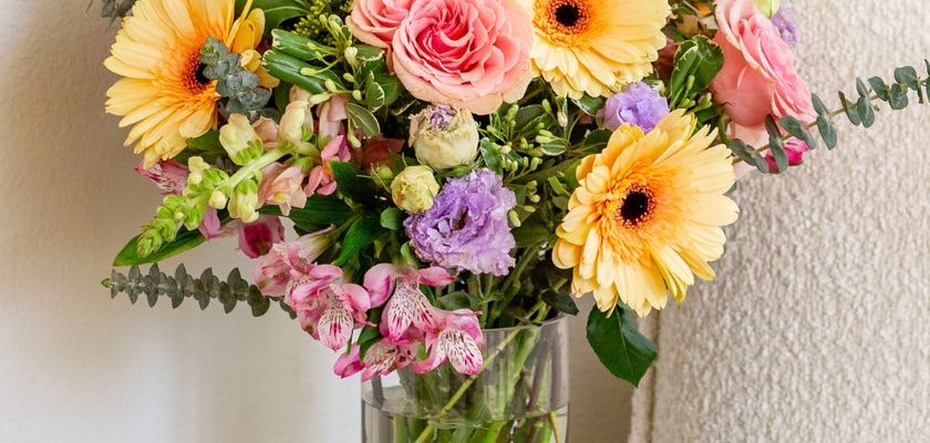 Bright and cheerful bouquet featuring pink roses, gerbera daisies, and colorful blooms.