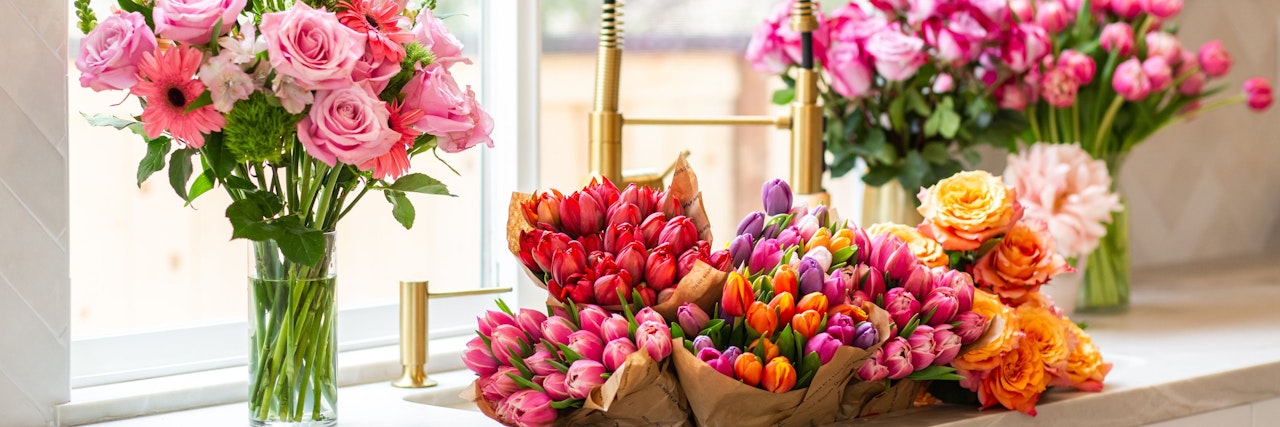 A vibrant display of colorful tulips and roses in elegant arrangements, perfect for gifts.