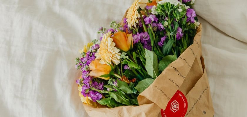 Vibrant bouquet of mixed flowers wrapped in craft paper, perfect for brightening any space.