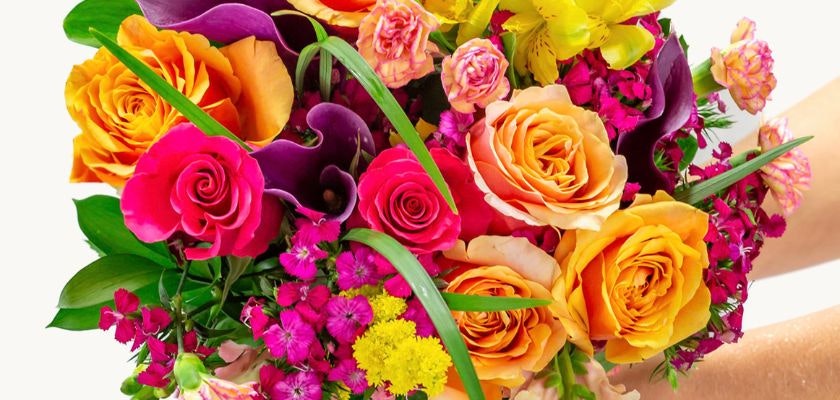 Vibrant floral bouquet featuring orange roses, purple calla lilies, and pink blooms.
