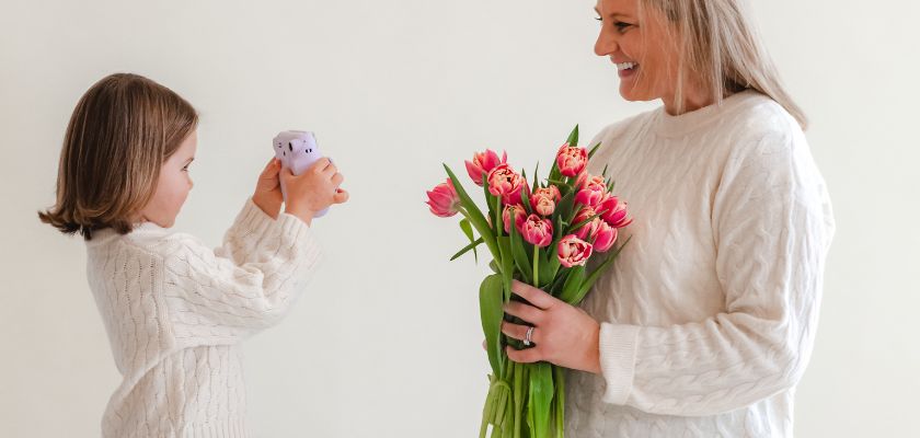 A joyful moment between a mother and daughter, celebrating with a vibrant tulip bouquet.
