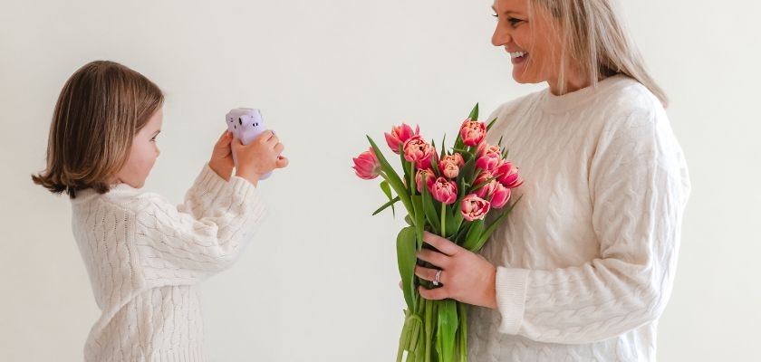 A joyful moment between a mother and daughter, celebrating with a vibrant tulip bouquet.