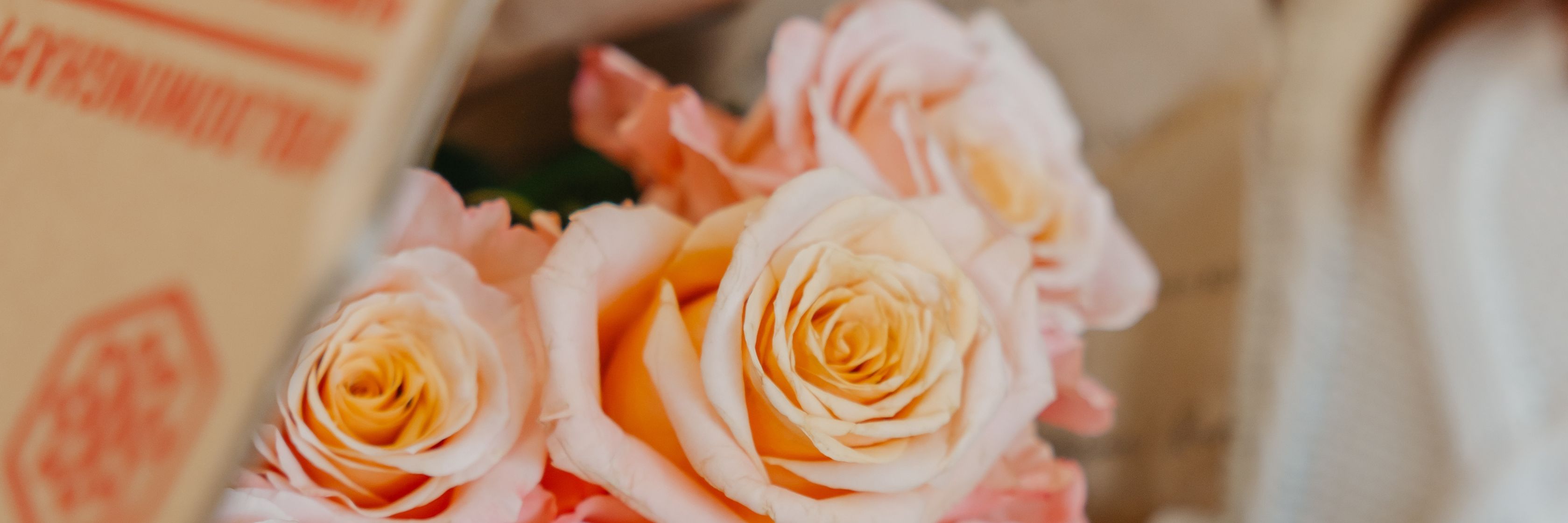 Beautiful peach and pink roses arranged gracefully in a gift box, perfect for any occasion.
