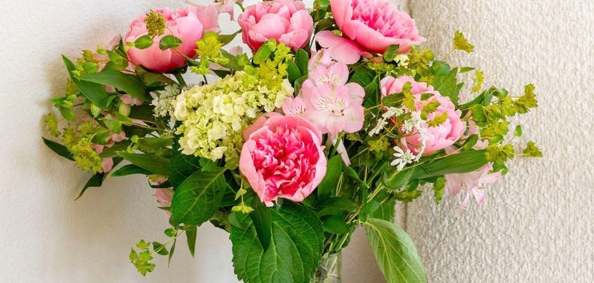 Beautiful bouquet of pink peonies and white blooms, elegantly arranged with lush greenery.