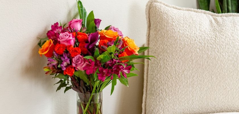 Vibrant floral arrangement with roses and exotic blooms in a stylish vase.