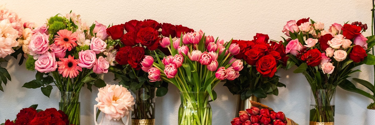 Colorful floral display featuring red roses, pink tulips, and cheerful gerbera daisies.