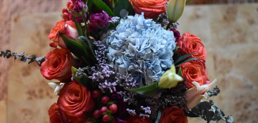 Vibrant bouquet featuring red roses, hydrangeas, and lush greenery, perfect for gifting.