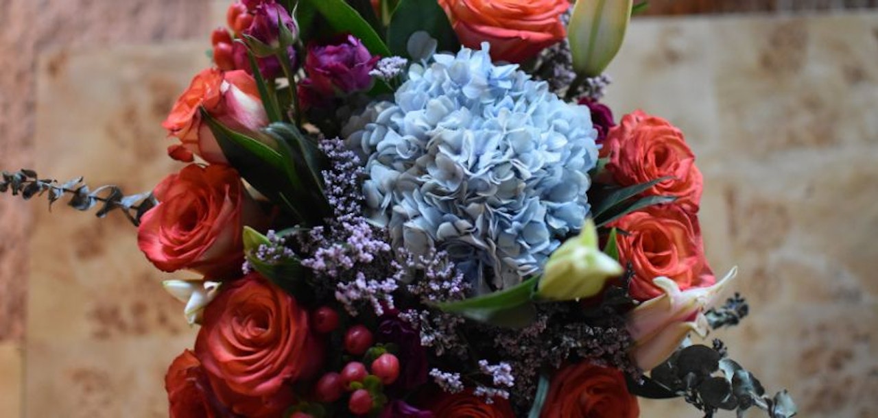 Vibrant bouquet featuring red roses, hydrangeas, and lush greenery, perfect for gifting.