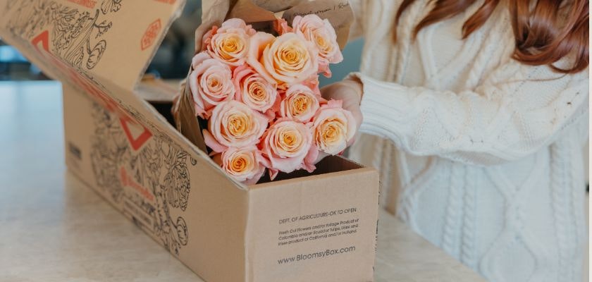 Beautiful peach and pink roses being unboxed from a subscription floral delivery.