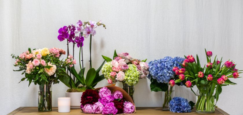 Elegant floral display with mixed bouquets, featuring roses, orchids, and tulips.