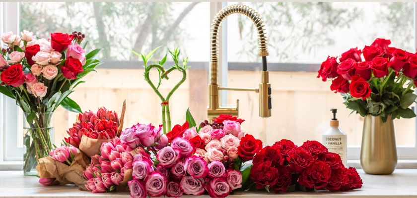 A vibrant collection of roses in various colors and arrangements on a kitchen countertop.