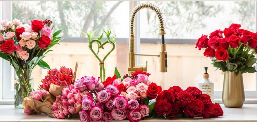 A vibrant collection of roses in various colors and arrangements on a kitchen countertop.