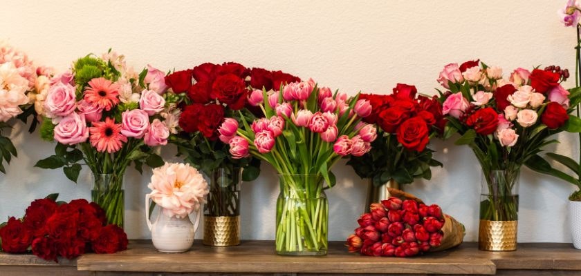Vibrant flower display featuring assorted roses and tulips in elegant vases, perfect for gifts.