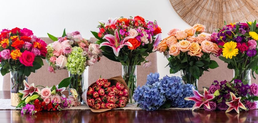 Brightly colored floral arrangements featuring roses, lilies, and hydrangeas in elegant vases.
