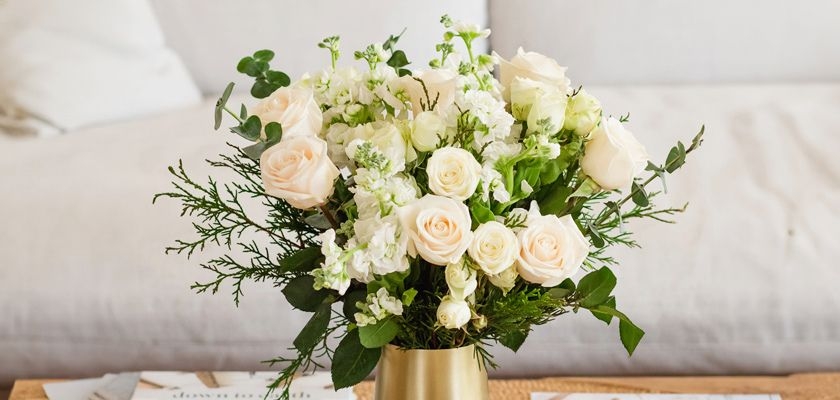 Elegant bouquet of creamy roses and white blooms in a modern vase, perfect for events.