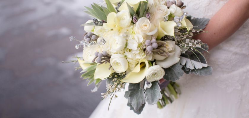 Elegant bridal bouquet featuring white roses, calla lilies, and lush greenery.