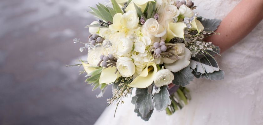 Elegant bridal bouquet featuring white roses, calla lilies, and lush greenery.