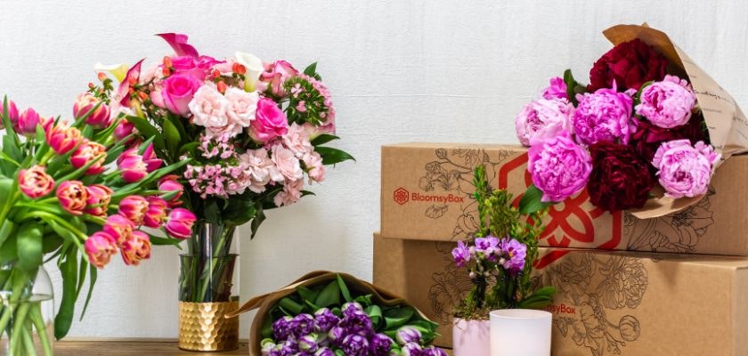 Vibrant floral arrangements featuring pink roses, tulips, and peonies in decorative packaging.