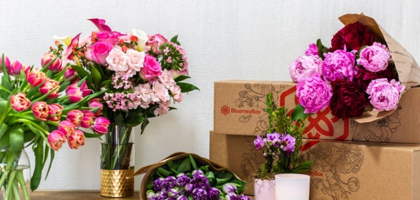 Vibrant floral arrangements featuring pink roses, tulips, and peonies in decorative packaging.