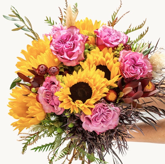 Vibrant bouquet featuring sunflowers and pink roses, perfect for cheerful occasions.