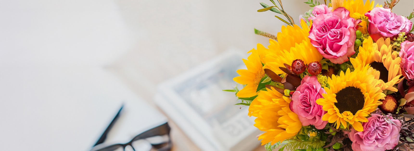 Vibrant bouquet of sunflowers and pink roses, perfect for brightening any space.