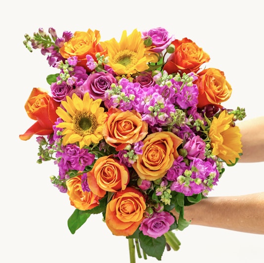 Vibrant mixed floral bouquet featuring sunflowers, roses, and colorful blossoms.