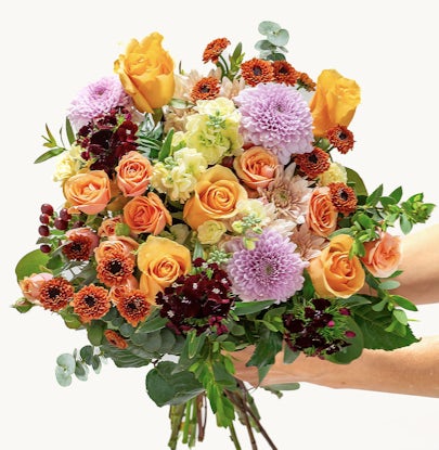 Vibrant bouquet featuring orange and purple blooms, perfect for any celebration or event.