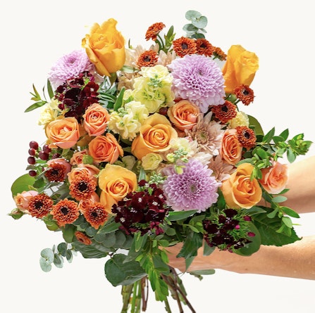 Vibrant bouquet featuring orange and purple blooms, perfect for any celebration or event.