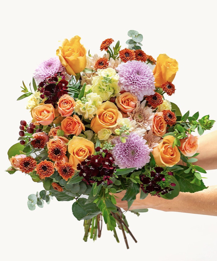 Vibrant bouquet featuring orange and purple blooms, perfect for any celebration or event.