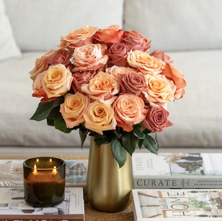 Luxurious bouquet of peach and pink roses in a stylish vase, enhancing any living space.