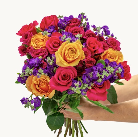 Vibrant bouquet of roses in red, orange, and purple hues, perfect for celebrations.