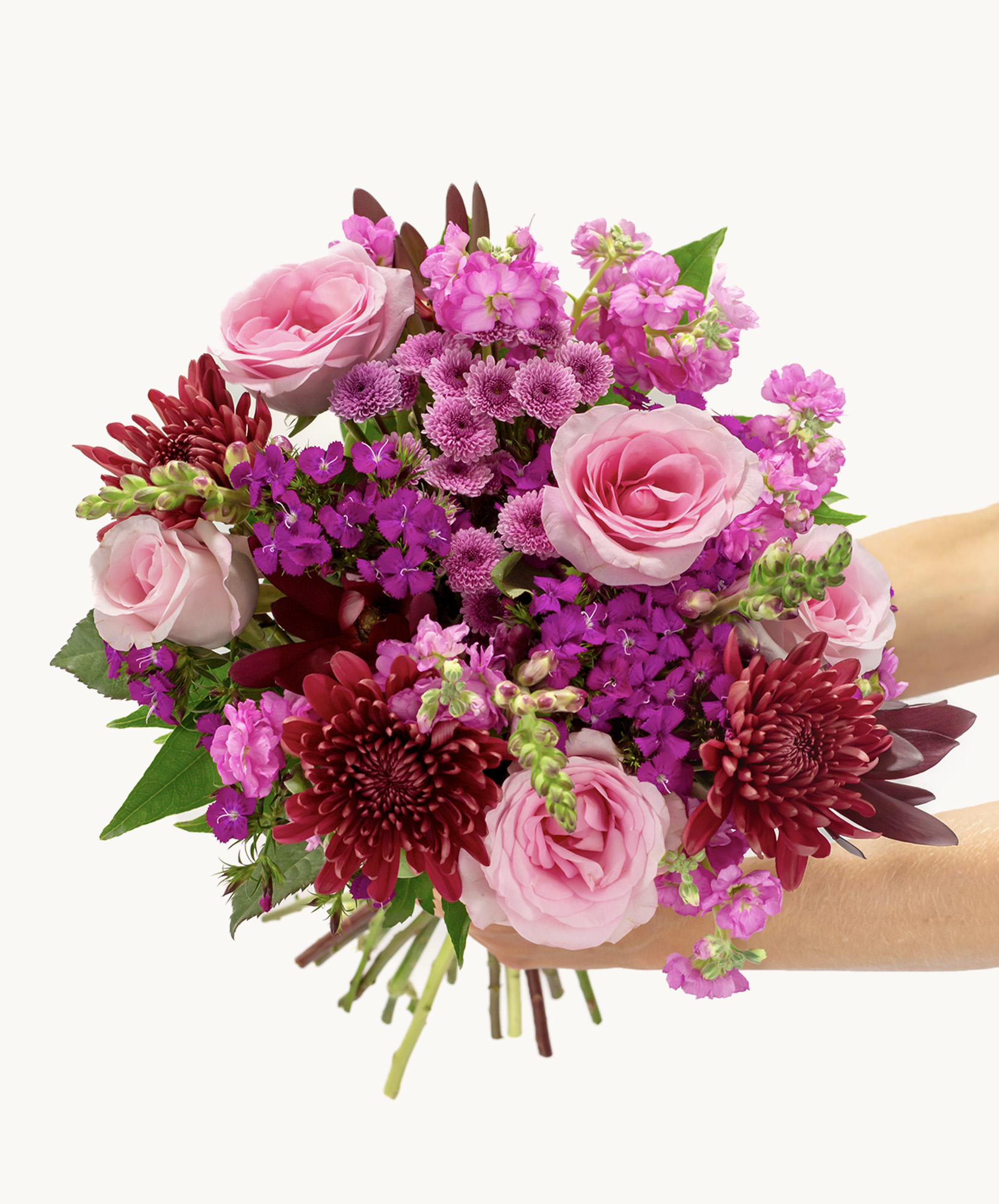 Vibrant bouquet featuring pink roses, purple flowers, and deep red chrysanthemums, beautifully arranged.