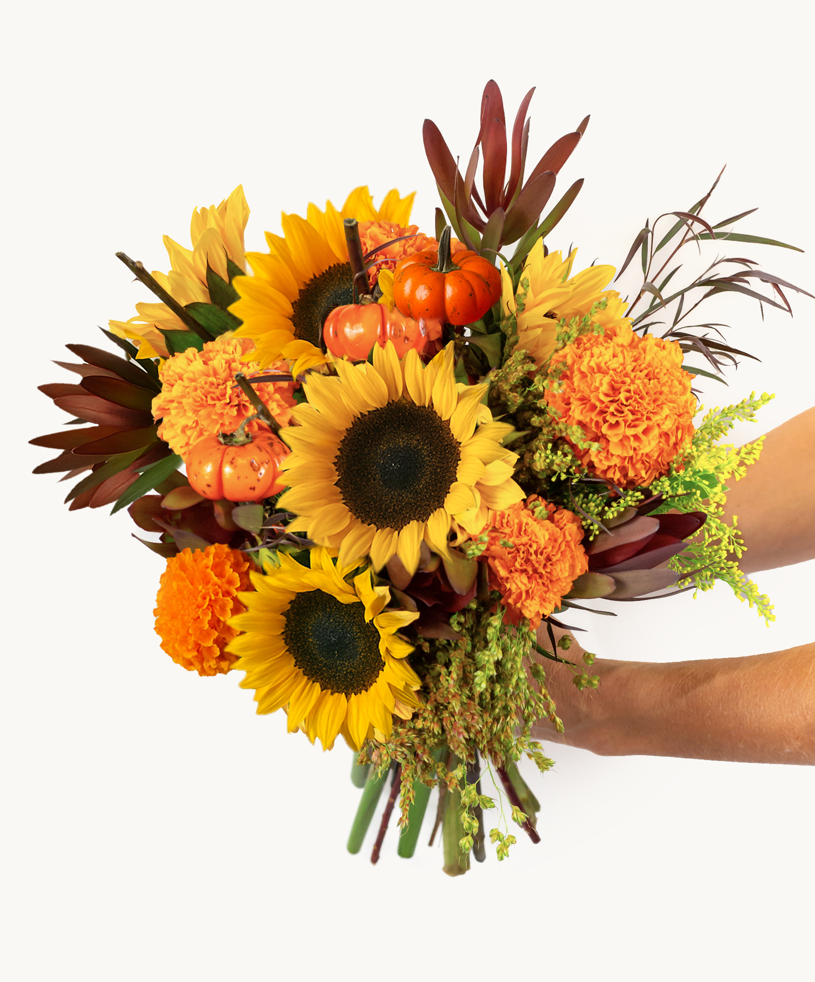 Vibrant floral bouquet featuring sunflowers, marigolds, and miniature pumpkins in autumn hues.