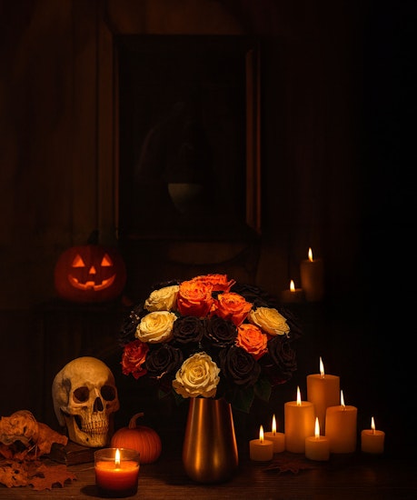 A hauntingly beautiful bouquet of dark and vibrant roses, set against autumnal Halloween decor.