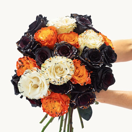 Vibrant bouquet featuring black, orange, and white roses, perfect for celebrations.