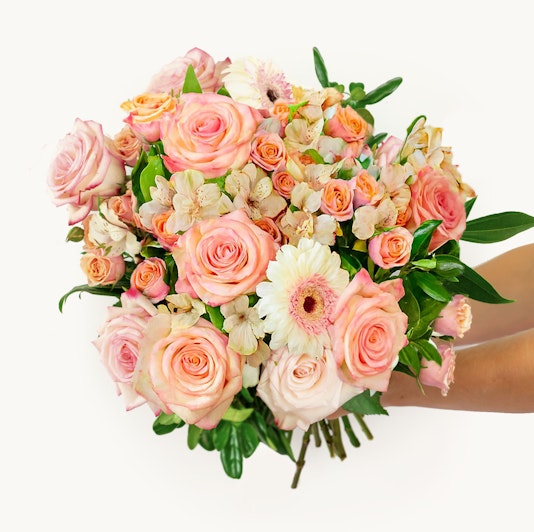 Vibrant bouquet of pink roses, daisies, and delicate flowers in a charming arrangement.