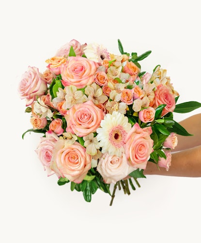 Vibrant bouquet of pink roses, daisies, and delicate flowers in a charming arrangement.