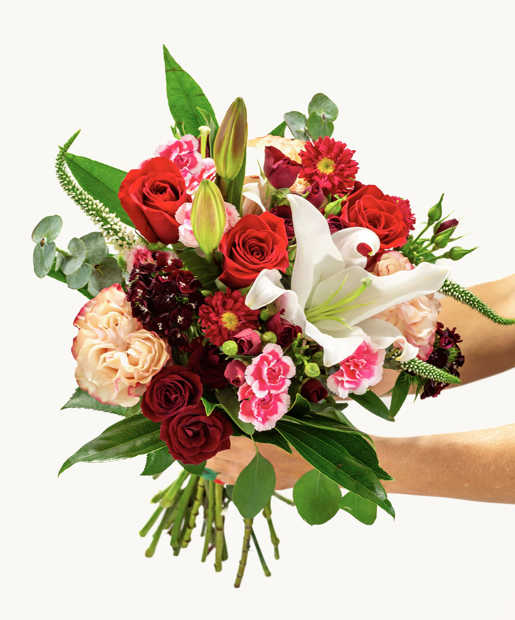 Vibrant bouquet featuring red roses, pink lilies, and assorted seasonal flowers, beautifully arranged.