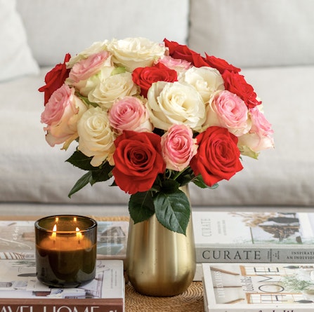 Bright red and pink roses in a gold vase, perfect for enhancing any home decor style.