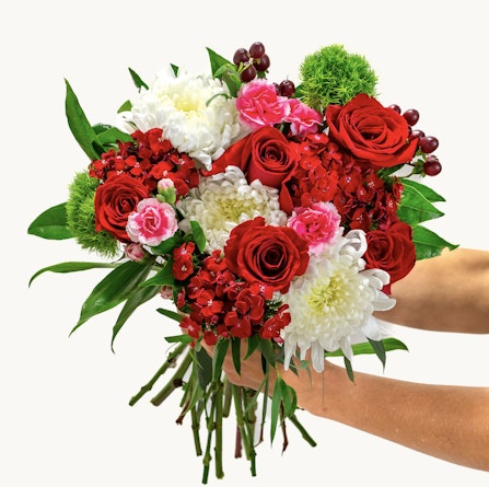 Vibrant bouquet featuring red roses, pink blooms, and white chrysanthemums, elegantly arranged.