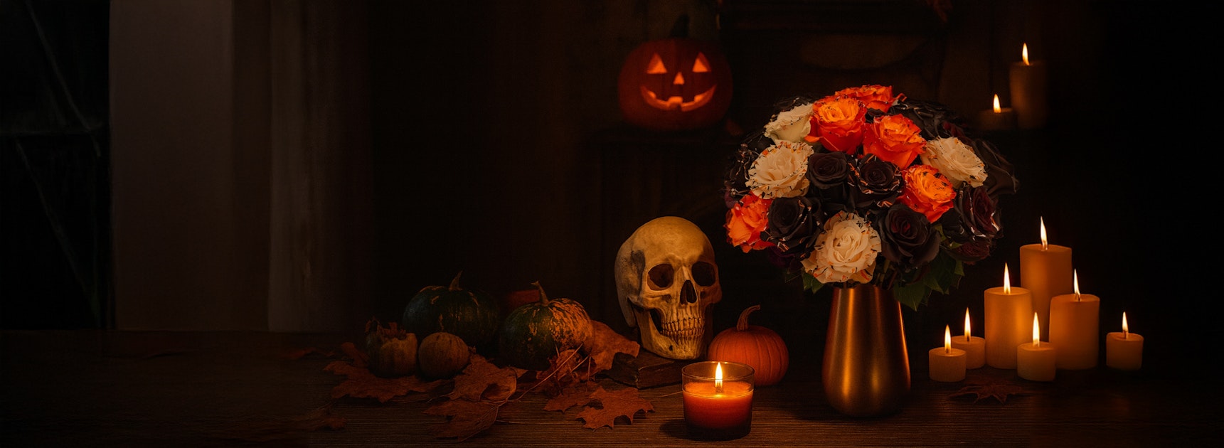 A hauntingly beautiful bouquet of roses beside candles and fall decor, perfect for Halloween.