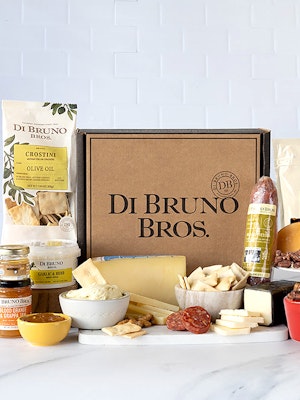 Gourmet cheese and charcuterie gift box featuring assorted meats, crackers, and snacks.