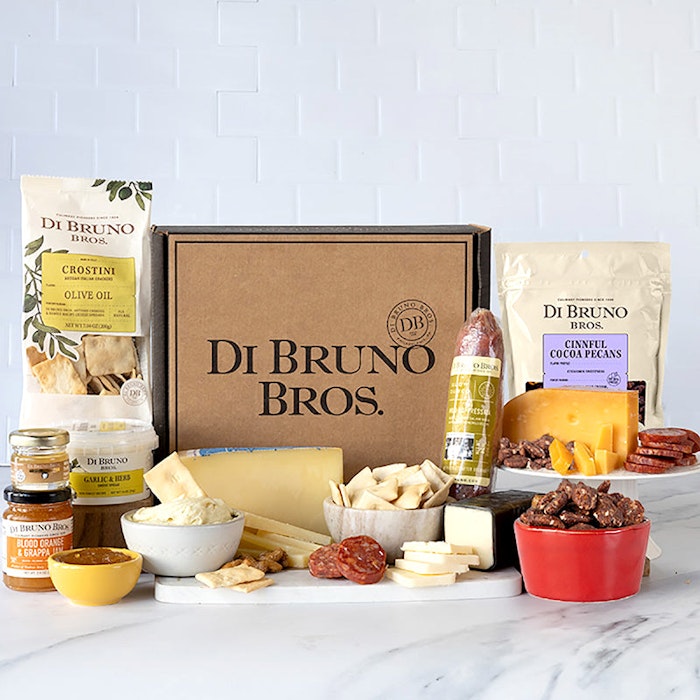 Gourmet cheese and charcuterie gift box featuring assorted meats, crackers, and snacks.