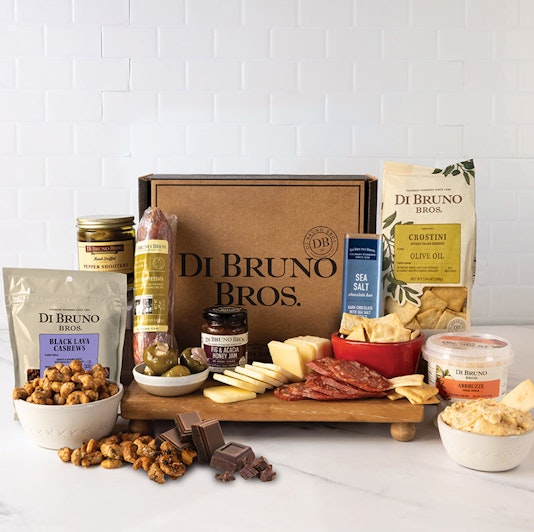 Gourmet snack box includes cheeses, meats, olives, and chocolates for a delightful treat.