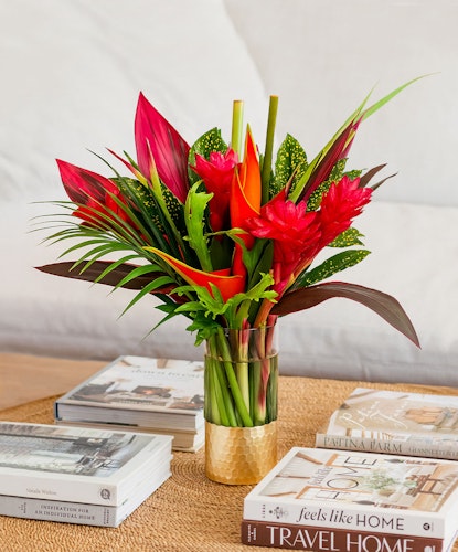 Vibrant tropical flower arrangement with red ginger, anthurium, and lush foliage.