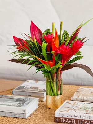 Vibrant tropical flower arrangement featuring red ginger and heliconia in a stylish vase.