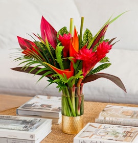 Vibrant tropical flower arrangement featuring red ginger and heliconia in a stylish vase.