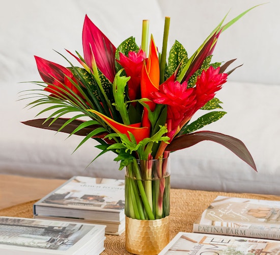 Vibrant tropical flower arrangement featuring red ginger and heliconia in a stylish vase.