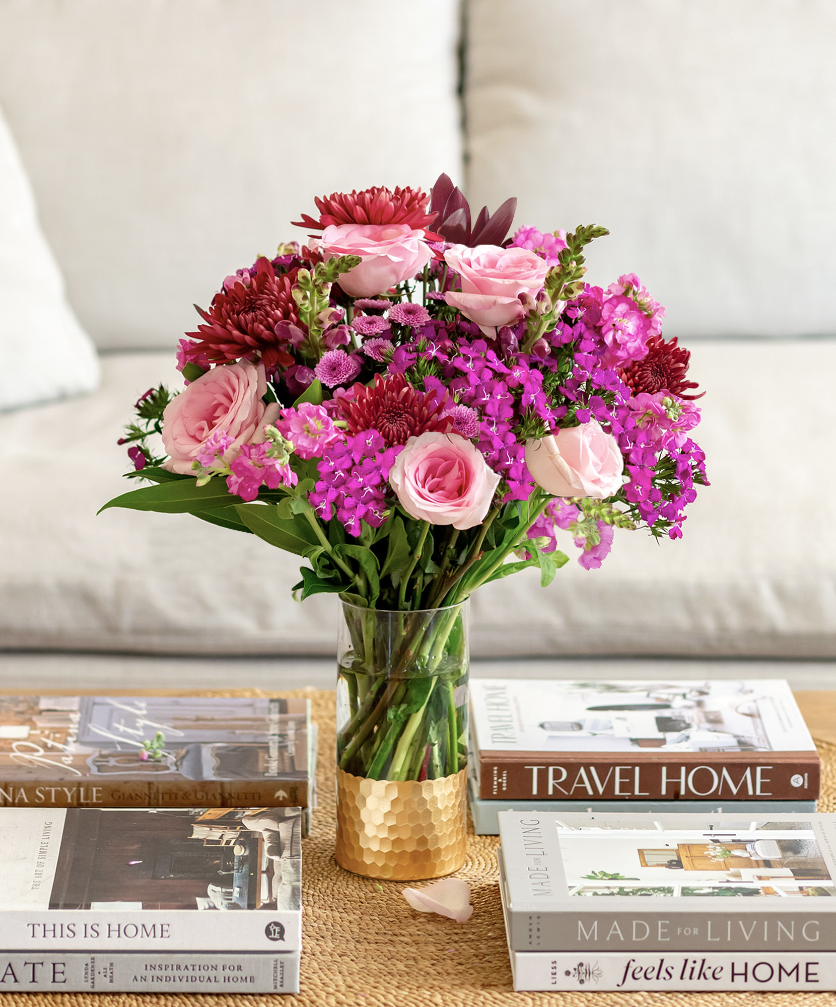 Vibrant floral arrangement with pink roses and purple blooms in a stylish vase, enhancing decor.